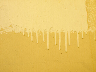 A yellow wall with streaks of paint. Background.