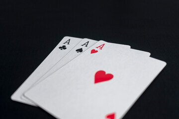triple aces of playing cards on black background