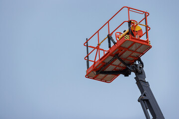Lift buckets machine against blue sky. Mobile construction crane for rent and sale. Aerial work platforms of a cherry pickers.