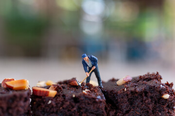 Miniature people, An employee is making a chocolate brownie. World chocolate day concept