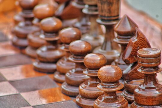 Lacquered chess pieces stand in a row and are ready for battle.  