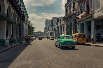 Old American car in the historic streets of Havana in Cuba with old buildings