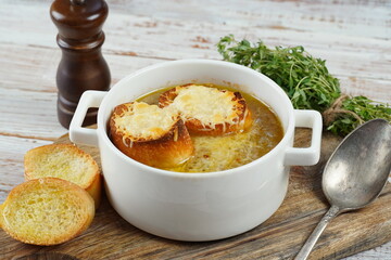 A classic French Onion Soup with with gruyere cheese and toasted baguette in a bowl