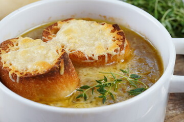 A classic French Onion Soup with with gruyere cheese and toasted baguette in a bowl