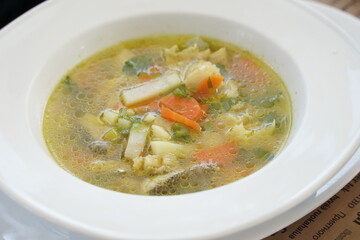 Psarosoupa - fish soup, traditional to Greek cuisine. Soup with white fish in a greek taverna