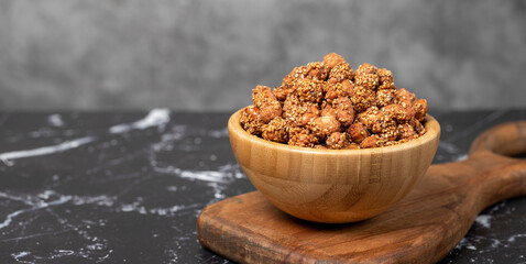 Honey with sesame peanuts. Sesame peanuts in wooden bowl. Superfood, Vegetarian food concept....