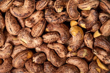 Cashew nuts . Roasted cashew nuts with shell closeup food background. Texture. Top view. Copy space banner