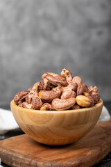 Cashew nuts . Roasted cashew nuts with shell in wooden bowl. Superfood. Vegetarian food concept. Healthy snacks. Close up