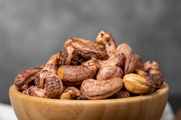 Cashew nuts . Roasted cashew nuts with shell in wooden bowl. Superfood. Vegetarian food concept. Healthy snacks. Close up