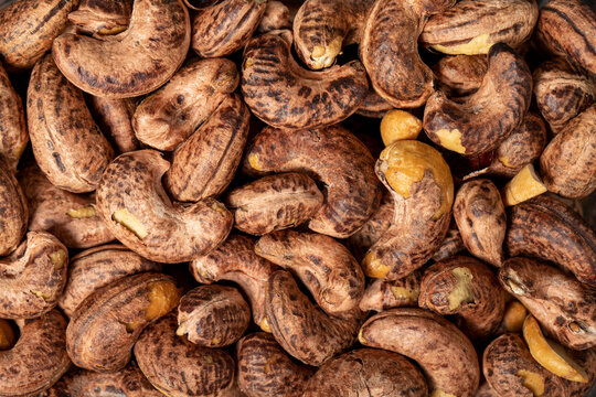 Cashew nuts . Roasted cashew nuts with shell closeup food background. Texture. Top view. Copy space banner
