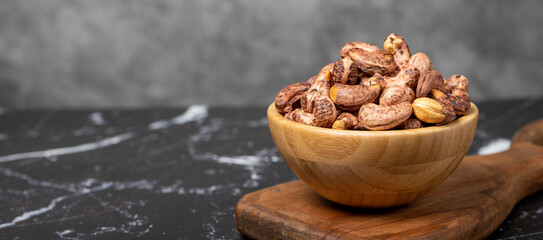 Cashew nuts . Roasted cashew nuts with shell in wooden bowl. Superfood. Vegetarian food concept. Healthy snacks. Copy space. Empty space for text