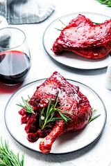 Baked duck legs in cherry and wine sauce with fresh rosemary. Gourmet dinner. White table background, top view