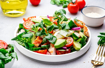 Chicken and vegetables salad with tomatoes,  avocado, cucumber, onion, lamb lettuce and sesame...