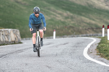 Fototapeta premium Young man riding uphill on his bicycle