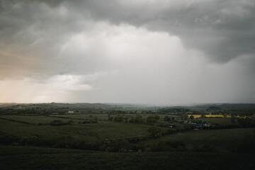 Obraz na płótnie Canvas Rain clouds coming in over fields