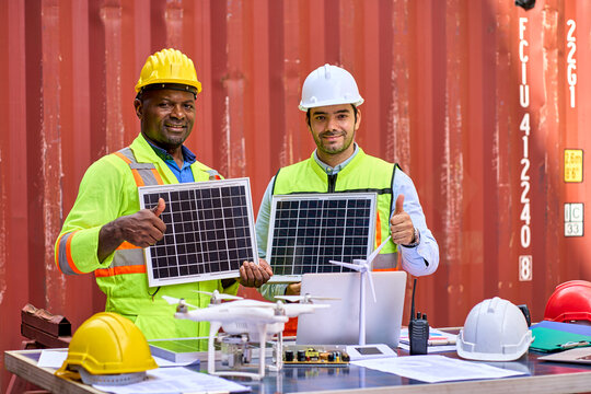 Diverse Engineer and foreman smile and trumb up to confirm quality of solar cell and process in container box background