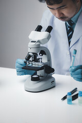 Lab assistant, medical scientist, chemistry researcher holds a glass tube through a chemical test tube, does a chemical experiment and examines a patient's sample. Medicine and research concept.