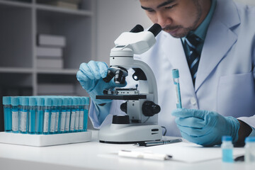 Lab assistant, medical scientist, chemistry researcher holds a glass tube through a chemical test tube, does a chemical experiment and examines a patient's sample. Medicine and research concept.