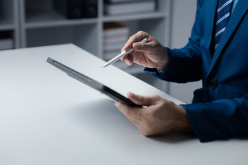 Person looking at data on tablet, businessman owner of startup company checking financial documents on tablet. The concept of using technology to manage information documents.