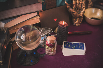Tarot cards and candles, witch magic bottles . Wicca, esoteric, divination and occult background with vintage magic objects for mystic rituals