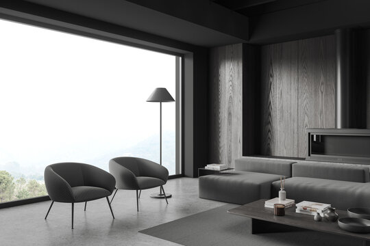 Grey living room interior with couch and armchairs near panoramic window