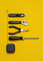 Flat lay composition with set of home repair tools on bright yellow background. Top view pattern with copy space.