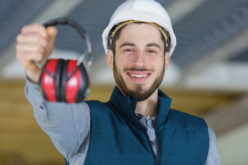 attractive and confident constructor carpenter with ear protection gear