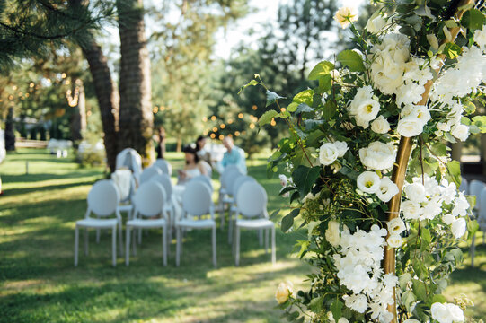Very beautiful outside ceremony. classical wedding in forest. Metal arch with flowers.
