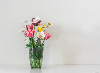 A bouquet of spring garden flowers on a light background, copy space