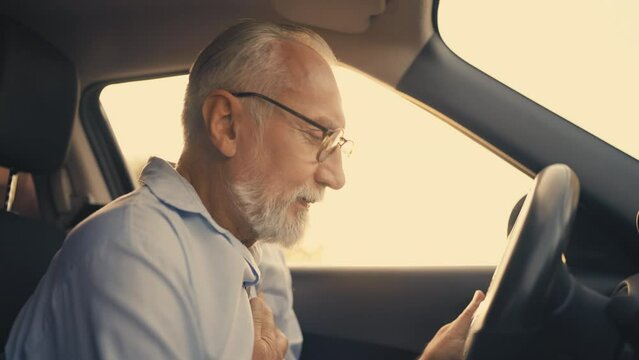 Elderly man having heart failure behind the wheel, health problems, seniors