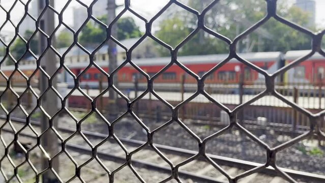 A Macro shot of a Local Train window view from inside of the cruising local train in the landscape railway network of the city of Mumbai
