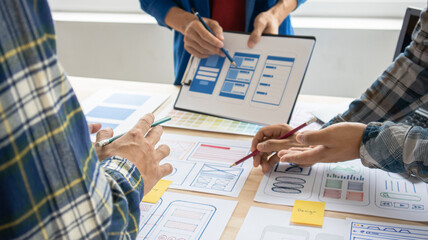 Close-up ux developers and ui designers use augmented reality to brainstorm on mobile app interface...