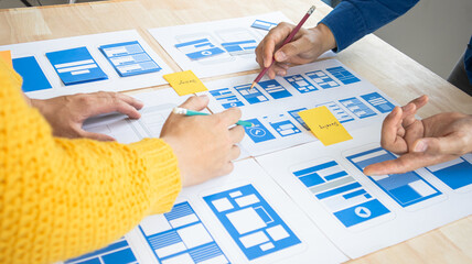 Close-up ux developers and ui designers use augmented reality to brainstorm on mobile app interface...
