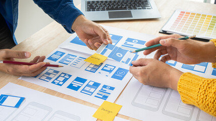 Close-up ux developers and ui designers use augmented reality to brainstorm on mobile app interface...
