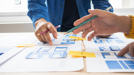 Close-up ux developers and ui designers use augmented reality to brainstorm on mobile app interface...