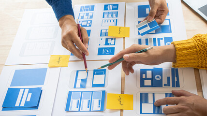 Close-up ux developers and ui designers use augmented reality to brainstorm on mobile app interface...