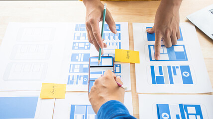Close-up ux developers and ui designers use augmented reality to brainstorm on mobile app interface...