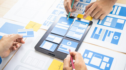Close-up ux developers and ui designers use augmented reality to brainstorm on mobile app interface...