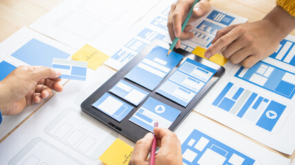 Close-up ux developers and ui designers use augmented reality to brainstorm on mobile app interface...