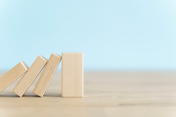 Falling wooden domino cubes. Insurance, business, risk, management concept.