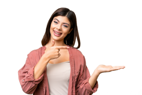 Young Russian woman over isolated chroma key background holding copyspace imaginary on the palm to insert an ad