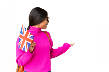 Young African American woman holding an United Kingdom flag over isolated chroma key background with surprise expression while looking side
