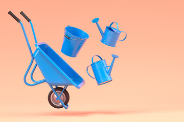 Garden wheelbarrow with garden tools like water can, rake and bucket on orange
