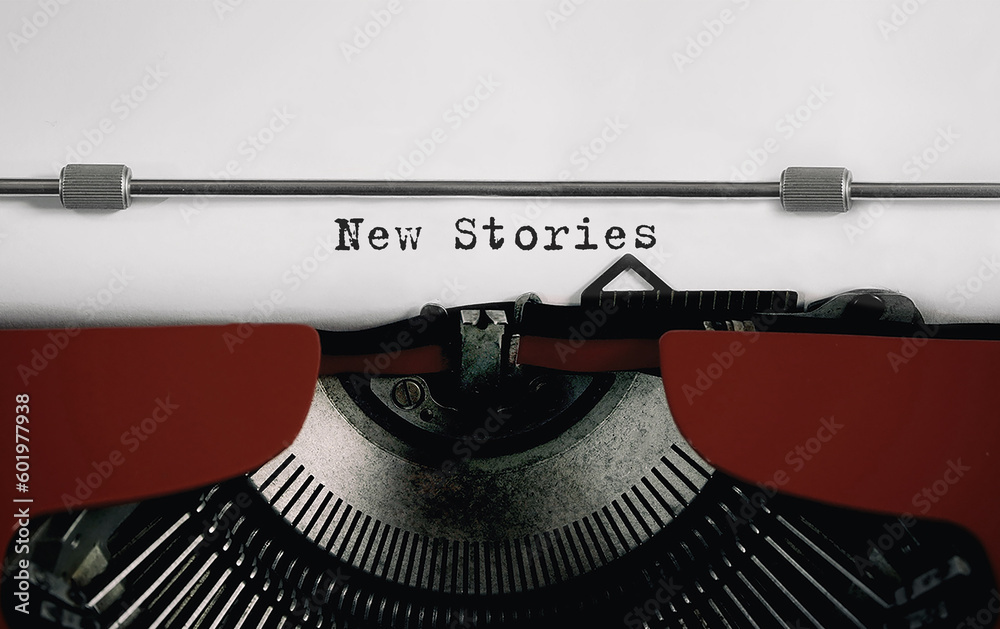 Fototapete text new stories typed on retro typewriter