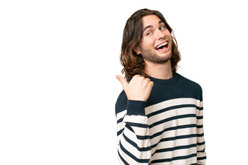 Young handsome man over isolated background pointing to the side to present a product