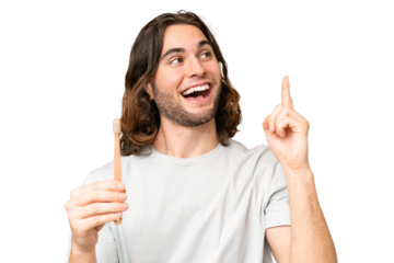 Young handsome man brushing teeth over isolated background intending to realizes the solution while lifting a finger up
