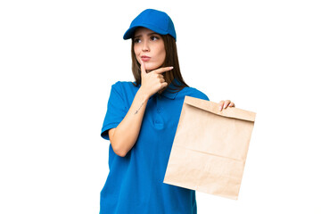 Young beautiful caucasian woman taking a bag of takeaway food over isolated background having doubts