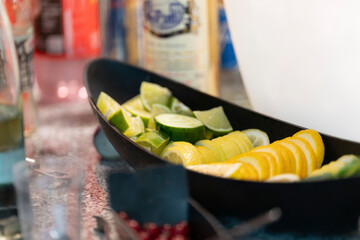 Schale mit Zitronen- und Limettenschnitzen an einer Bar