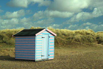 Naklejka premium Colorful beach hut in the sand dunes by the coast