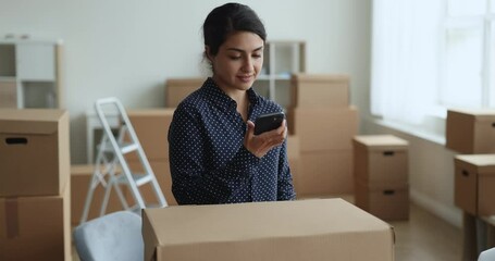 Young Indian businesswoman calls to courier service for sending prepared parcel box for customer. Client of reliable, trustworthy, express transporting company, quick dispatch, distribution, business